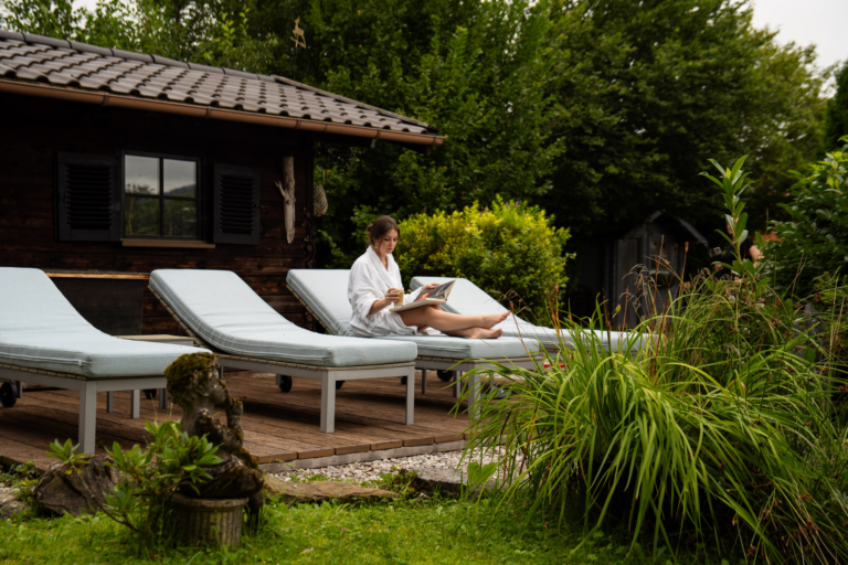 Junge Frau auf der Sonnenliege im Garten